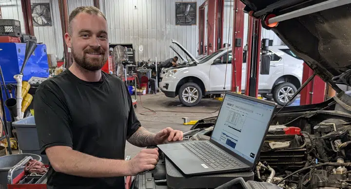 Auto Diagnostics In Grand Blanc Township, MI At Grand Pointe Automotive. Mechanic using laptop in garage.