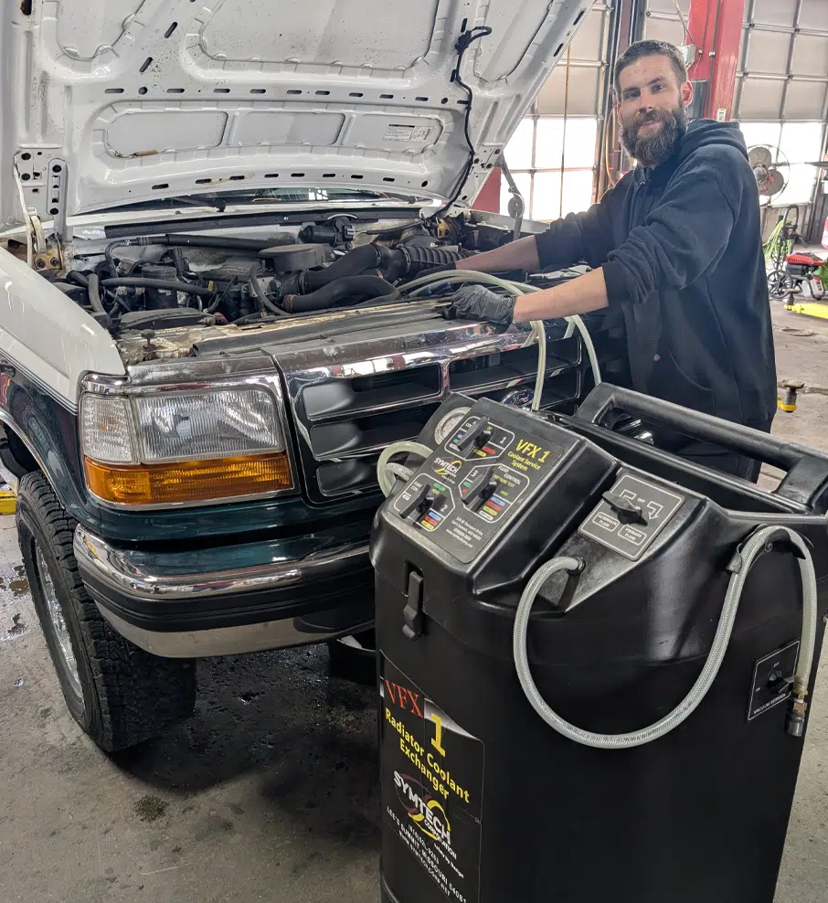 Preventative Maintenance In Grand Blanc Township, MI At Grand Pointe Automotive. Person servicing vehicle engine fluids.