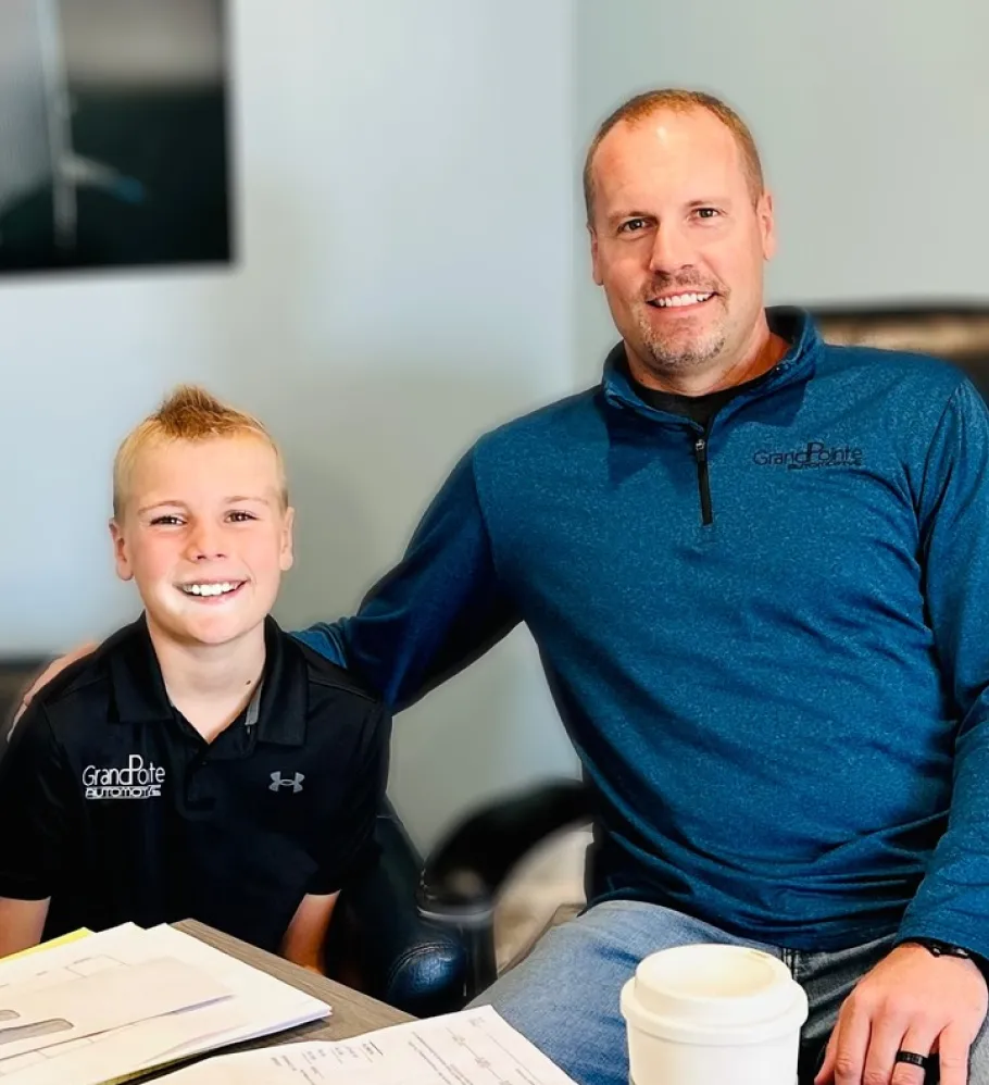 About Us, Auto Repair shop In Grand Blanc Township, MI At Grand Pointe Automotive. Man and boy sitting together.