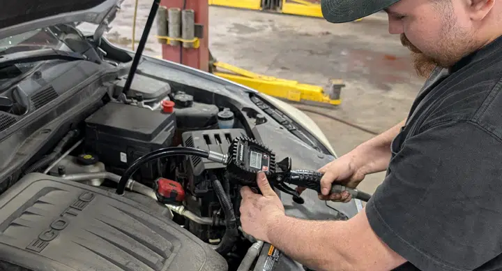 Oil Change In Grand Blanc Township, MI At Grand Pointe Automotive. Man performing car maintenance service.