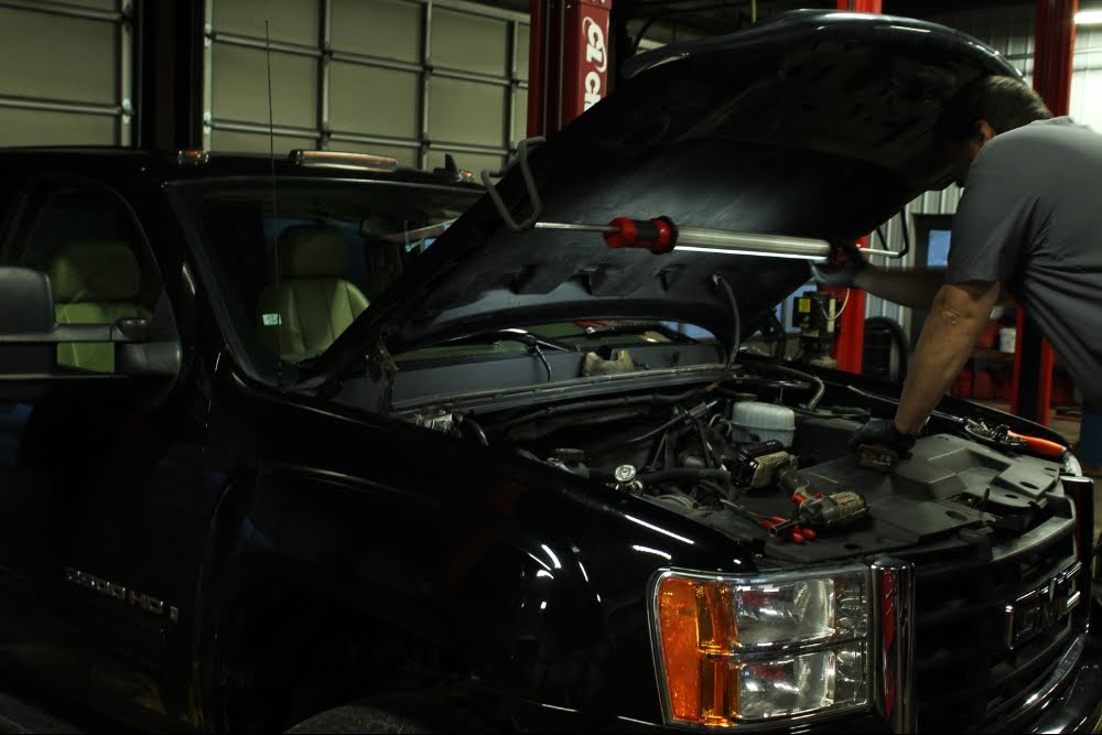 Mechanic inspecting engine in garage