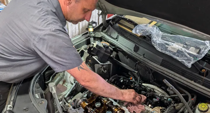 Engine Repair & Replacement In Grand Blanc Township, MI At Grand Pointe Automotive. Mechanic working on car engine components.