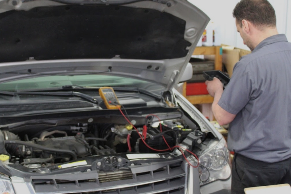 Battery Testing Service, Battery Test in Grand Blanc Township MI At Grand Pointe Automotive. Auto technician performing battery testing on a vehicle