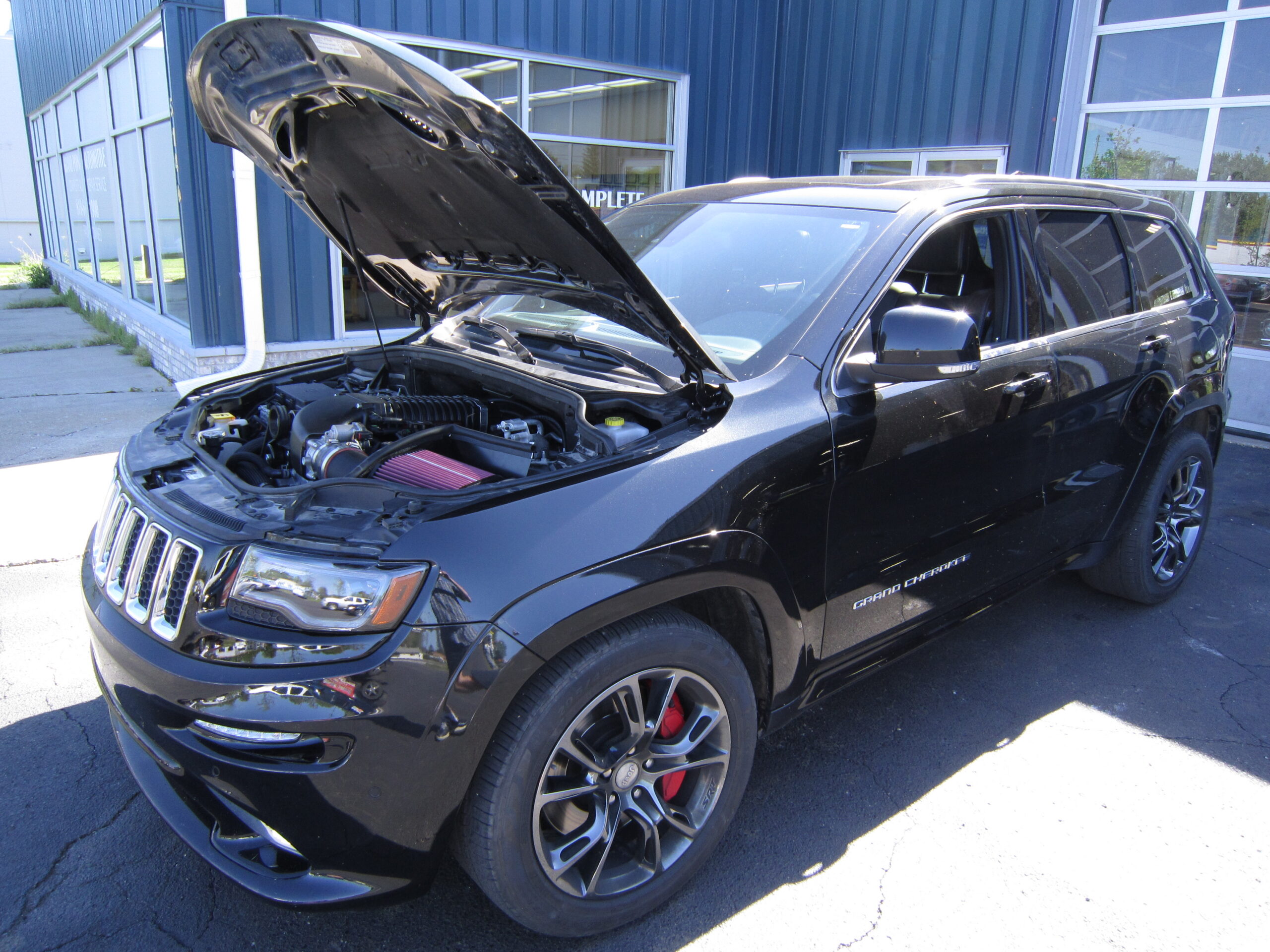 Spring Auto Maintenance in Grand Blanc Township MI At Grand Pointe Automotive. Vehicle with open hood parked outside for maintenance